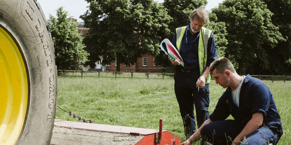 Teacher instructing student with a tractor