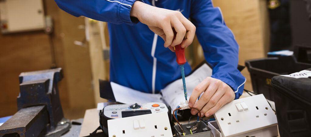 students stood around computer smiling